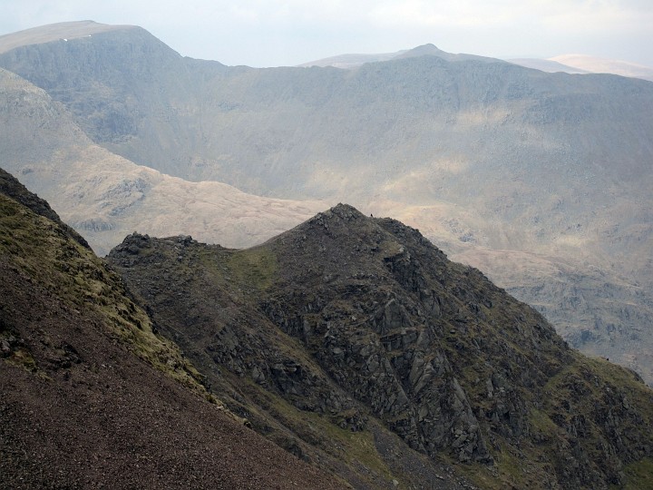 IMG_3221.JPG - Near the top of Fairfield.  Flinty Grave(?) with at least one person on the ridge (looks like a fun path but not marked on the maps).  Striding Edge and Helvellyn in the distance.